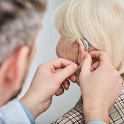 A woman getting her hearing aids adjusted by an audiologist.