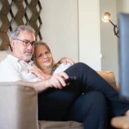 Older couple relaxing on the couch and watching TV together.