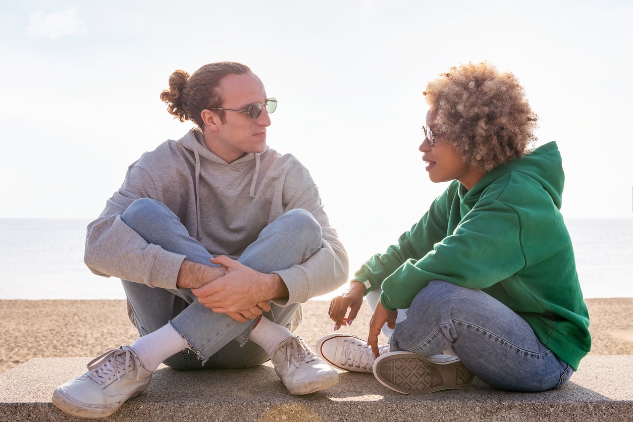 Couple sitting on the beach talking