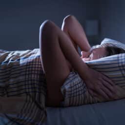 Woman holds pillow while sleeping