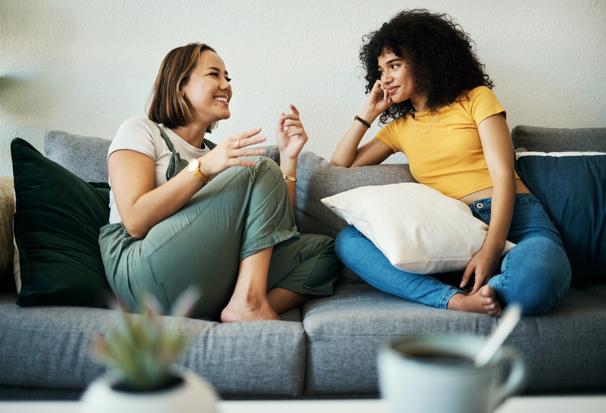 Two women talking on a couch