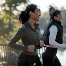 Three Women Jogging Outdoors in a Scenic Park at Sunrise