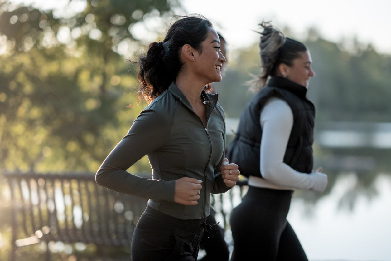 Three Women Jogging Outdoors in a Scenic Park at Sunrise